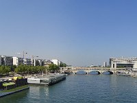 Depuis la passerelle Simone de Beauvoir, vue imprenable sur  la piscine flottante Joséphine Baker,  le pont de Bercy et, à droite, le ministère de l’Économie et des Finances, avec ses pieds dans l'eau.